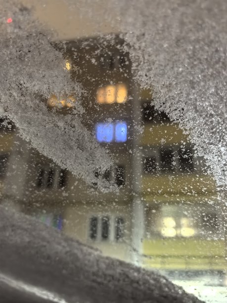 透过雪覆盖的窗户看到的景象，窗户上的雪，冬天的城市，冬季城市景观，窗户上的霜，城市里的冬天，雪景街道的美丽照片图片下载