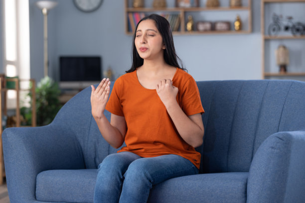 穿着休闲服的年轻美丽女孩在家中沙发上坐着的照片图片下载