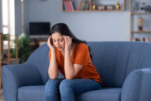 一名穿着休闲服的漂亮年轻女孩在家坐在沙发上的照片图片下载
