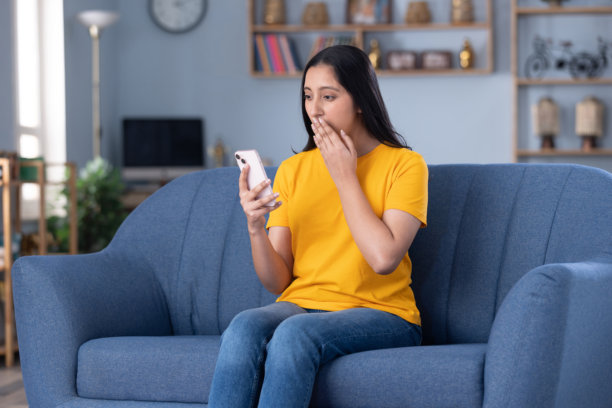 穿着现代服装的美丽年轻女孩在家中坐在沙发上喝咖啡的图片图片下载