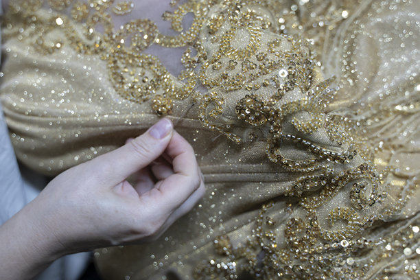 一位设计师正在缝制一条黄色晚礼服（素材图）图片下载