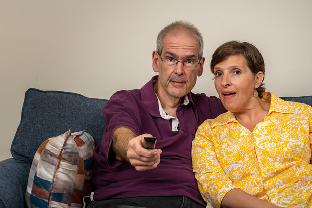 一对老夫妇坐在沙发上一起看电视图片下载