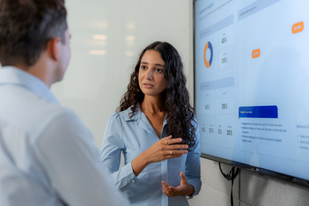 女商人会议室里向男同事解释数字屏幕上的数据图表。团队协作制定公司战略、分析和项目规划。图片下载