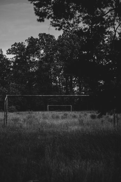 废弃的、杂草丛生的体育场，靠近公园，黑白照片图片下载