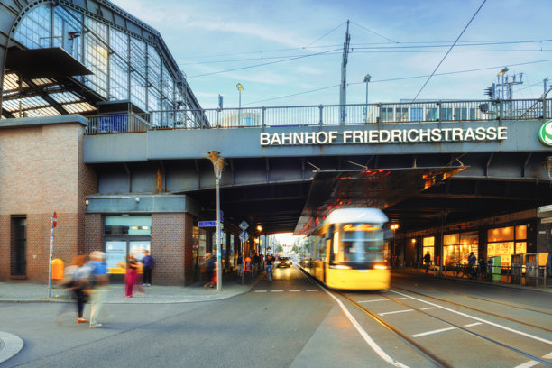 日落时分，柏林弗里德里希大街火车站前有轨电车的长曝光照片图片下载