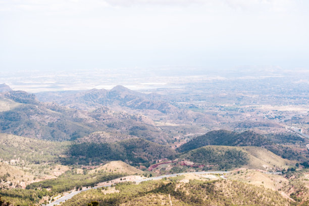 广阔的沙漠山地景观，天空晴朗，远眺城市景色图片下载