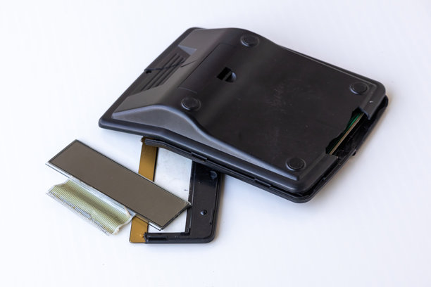 特写镜头：一个破碎的黑色计算器，屏幕脱落，内部零件破碎散落在白色背景上。象征金融失败、错误、债务和损坏的技术。图片下载