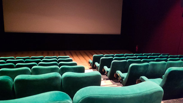 空无一人的电影院礼堂，配有蓝绿色座椅和空白屏幕图片下载