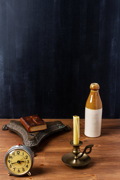 黑色墙壁旁棕色木桌上的各种复古物品图片下载