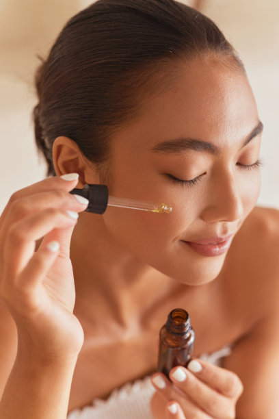 女性涂抹护肤精华，打造健康透亮肌肤图片下载