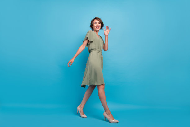 照片：快乐迷人的年轻女子手持礼物，戴着生日帽，在蓝色背景下庆祝，孤立。图片下载