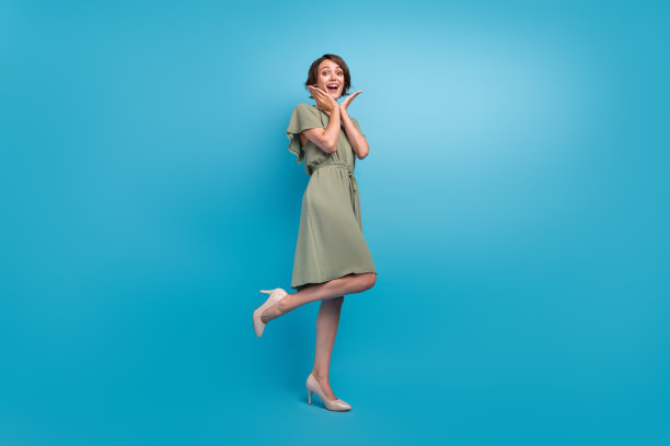 照片：快乐迷人的年轻女子，手持生日礼物，戴着生日帽，在蓝色背景上庆祝，孤立图片下载