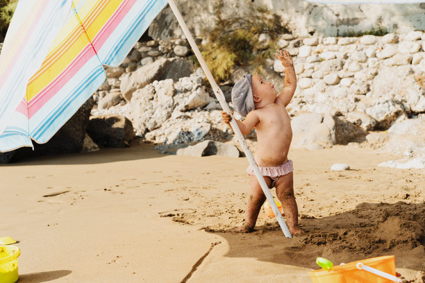 一个快乐的小女孩在海边沙滩上玩耍的照片图片下载