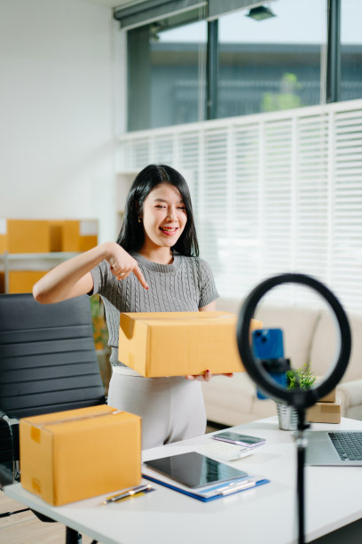 时尚博主概念，年轻亚洲女性通过视频直播售卖衣物。初创小企业，使用智能手机或平板电脑接收订单图片下载