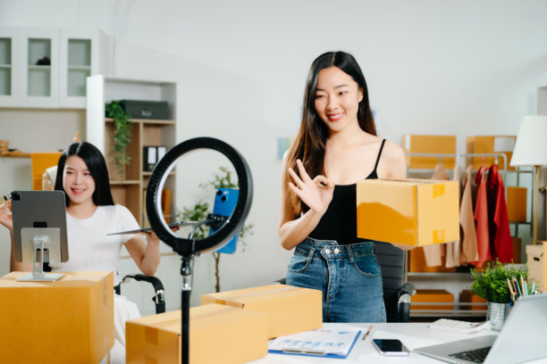 时尚博主概念，年轻亚洲女性在视频直播中售卖衣物。创业小企业，使用智能手机或平板电脑接收和查看订单。图片下载