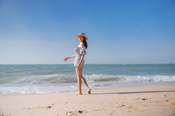 一位美丽的女子戴着一顶质感自然的草帽，草帽既能遮阳，又增添了夏日的时尚感，营造出俏皮活泼的氛围，突显了照片的愉悦与放松情绪。图片下载
