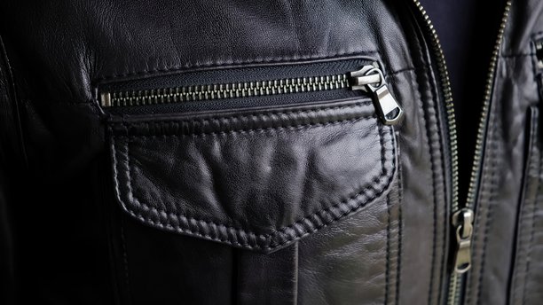 男人正在拉上皮夹克的口袋。夹克金属拉链特写。骑行服或朋克风。休闲服饰。高质量照片图片下载