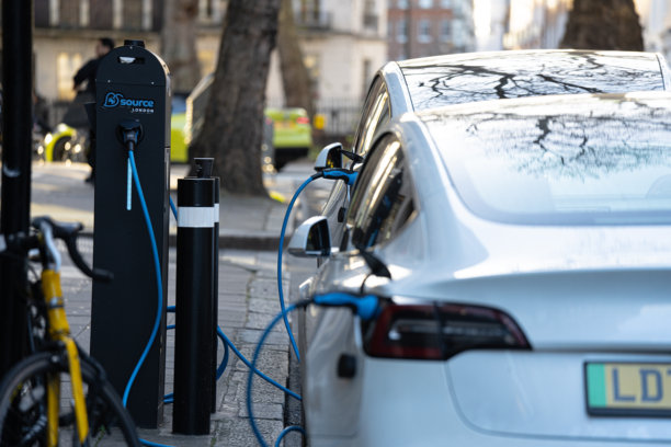 特斯拉电动汽车插入路边充电桩，充电单元，电动汽车后视图，伦敦市中心图片下载