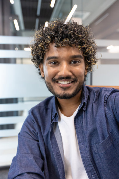 室内垂直特写照片，一名印度男子正对着手中持有的相机说话图片下载