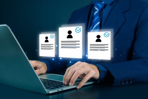 商务招聘人员在笔记本电脑上审阅带有已验证个人资料图标的电子简历，招聘和雇佣概念，人力资源管理，候选人筛选，人才招聘和企业技术。图片下载