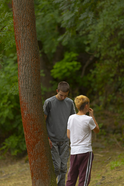 抓拍的年轻孩童在公园红色栏杆旁的非摆拍照片图片下载