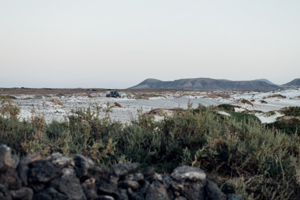 黄昏时分，在富埃特文图拉岛的沙漠景观中行驶的越野车图片下载