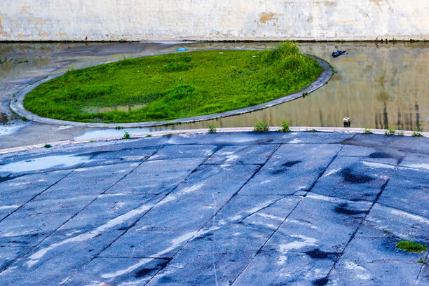 废弃的停车场，带有圆形绿岛和潮湿的铺面，供素材使用图片下载