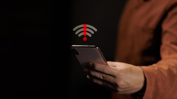 一个人拿着智能手机，上面显示着断开的Wi-Fi信号和红色警报图标。图片下载