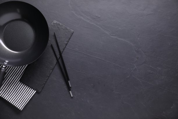 黑色桌面上的空铁锅和筷子，俯视角度，留有文字空间图片下载