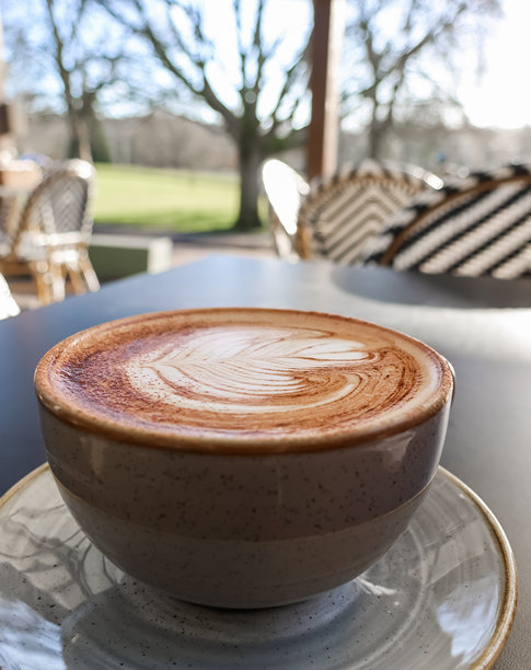 英格兰赫默尔亨普斯特一家户外咖啡馆的陶瓷杯卡布奇诺，上面有咖啡师拉花艺术图片下载