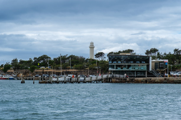 2025年12月在旗杆角灯塔拍摄的照片。图像捕捉了历史悠久的灯塔、周围的海岸景观以及享受海景和户外活动的游客。图片下载