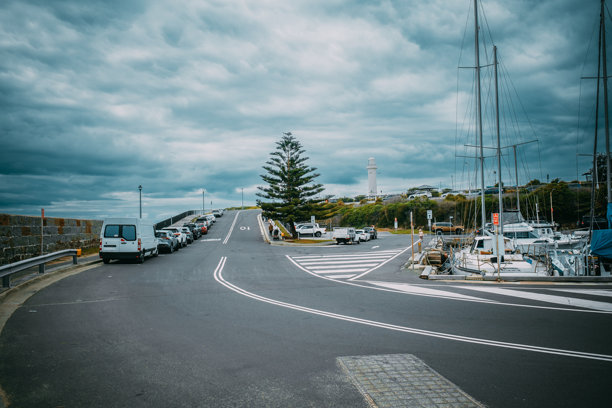 2025年12月在旗杆角灯塔拍摄的照片。图像捕捉了历史悠久的灯塔、周围的海岸景观以及享受海景和户外活动的游客。图片下载