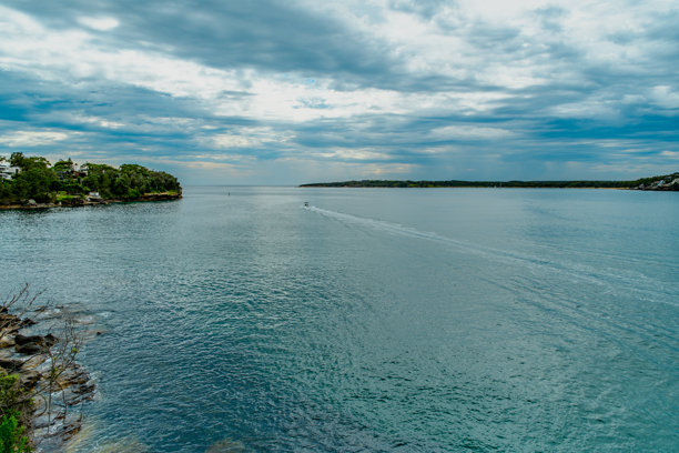 这张照片摄于2025年12月的悬崖步道上的Hungry Point保护区，展示了望向Bundeena和Maianbar的海岸线景色，人们正在享受徒步和海滨生活。图片下载