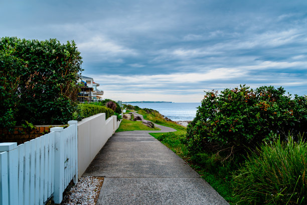 这张照片摄于2025年12月，地点是悬崖步道上的Hungry Point Reserve，展示了望向Bundeena和Maianbar的海岸线景色，人们在此享受徒步和海滨生活。图片下载
