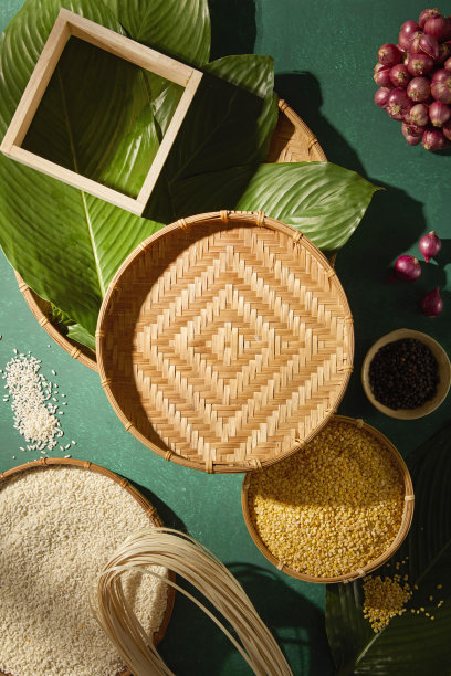 竹编纹理的粽子，绿底上摆放着原材料。适用于春节广告、文化展示和传统食品品牌宣传的场景。图片下载