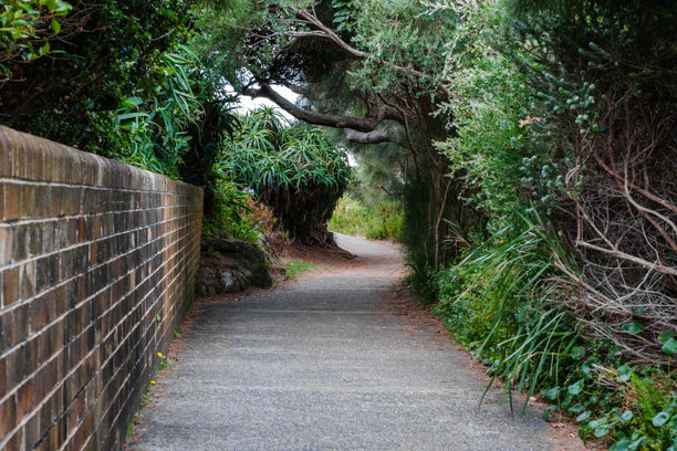 这张照片摄于2025年12月，在悬崖步道上的Hungry Point Reserve，展示了望向Bundeena和Maianbar的海岸线景色，人们正在享受徒步旅行和海滨生活。图片下载