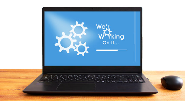 工作台上的笔记本电脑屏幕显示系统更新通知。任何电脑或笔记本的系统更新或升级提醒。蓝色的软件升级图标。屏幕显示。图片下载