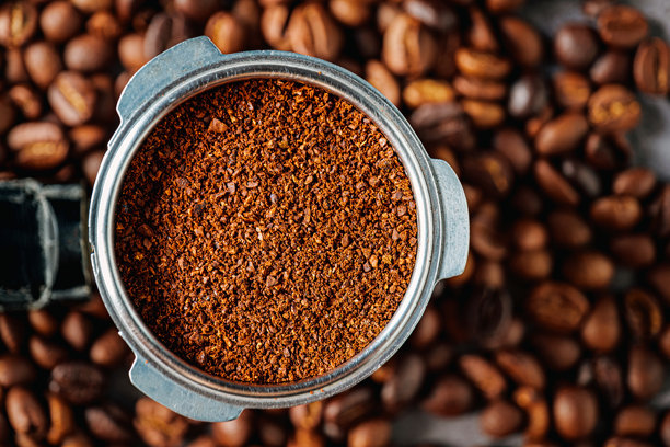 咖啡粉在手柄式滤杯中或咖啡粉在便携式滤杯手柄中，以及咖啡豆，俯视图片下载
