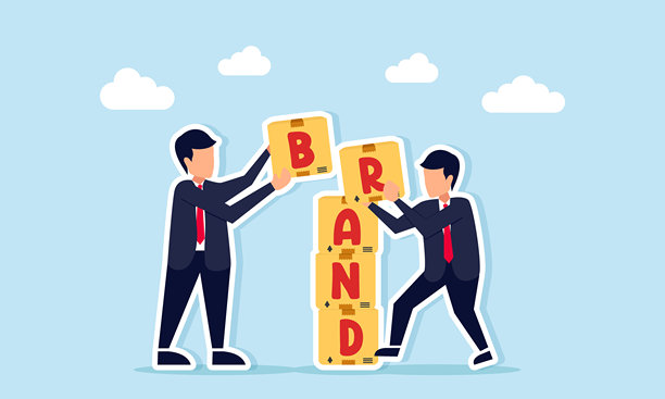 两位商人合作堆叠带有品牌标签的箱子，展示了打造企业品牌的团队合作精神。图片下载