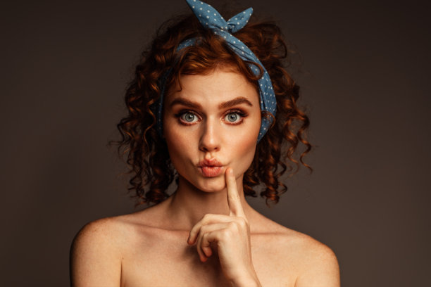 卷发俏女郎，戴着蓝色波点发带的肖像照图片下载