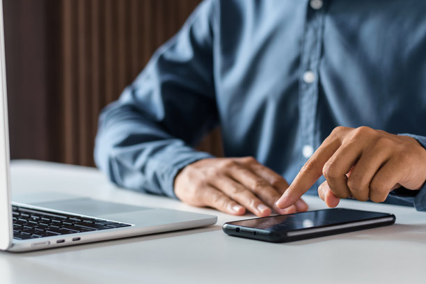 商务人士在办公室书桌前使用手机应用程序触摸智能手机屏幕图片下载