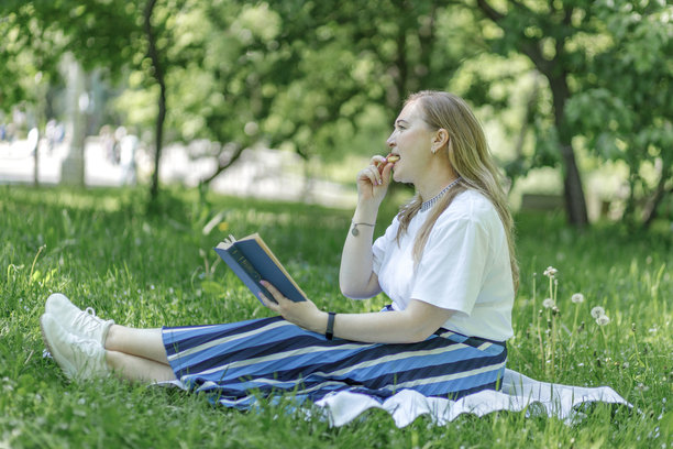 一位金发中年女性在花园的躺椅上使用笔记本电脑工作，绿色居家办公理念。图片下载