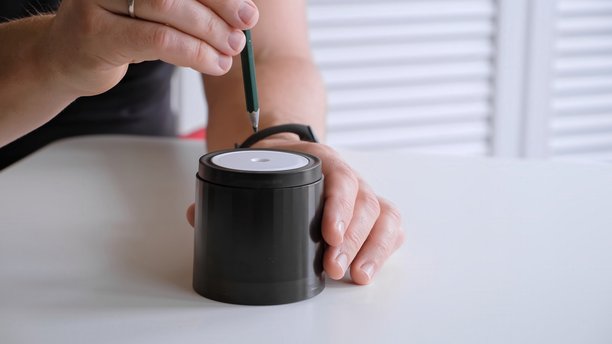 男性手将铅笔插入电动卷笔刀特写侧视图。办公室文具工具。为绘画和素描做准备。高质量照片图片下载