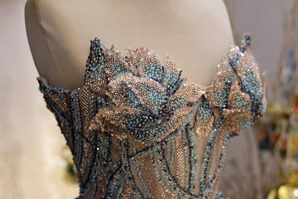 婚纱店里模特身上展示的金色和蓝色晚礼服（素材照片）图片下载