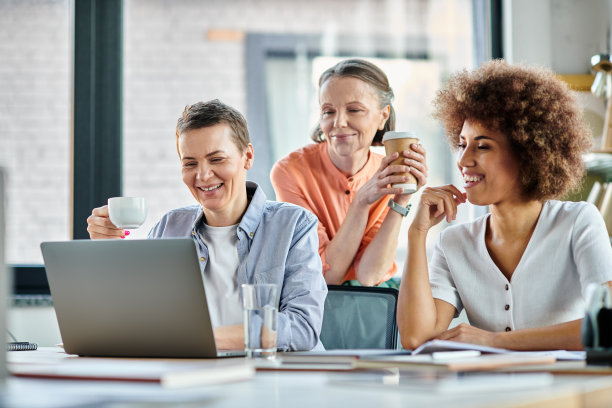 女性在明亮的办公室空间里协作，享受咖啡，共同工作图片下载