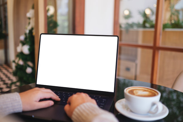 咖啡馆里，一名女子正在笔记本电脑上打字工作的样机图，电脑屏幕为空白白色桌面图片下载
