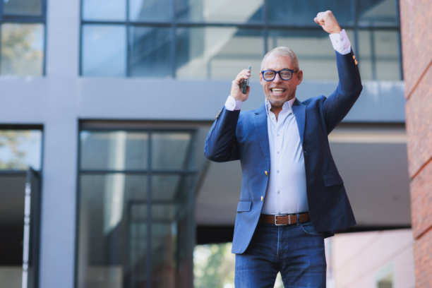 中年商人庆祝成功，接到好消息的电话图片下载