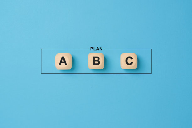 蓝色背景上的木质方块，上面标有计划 a、b 和 c。从三个选项中选择一个商业战略计划。图片下载