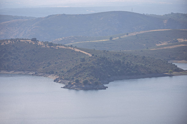 长焦全景照片，视觉上压缩了水库后面的山峦，形成了蓝色和绿色的层次感图片下载