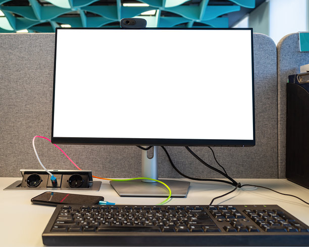 现代办公室房间的桌子上放着一台带有空白白屏的电脑、键盘和智能手机，可用于展示艺术作品或文本的模板，并留有复制空间。图片下载